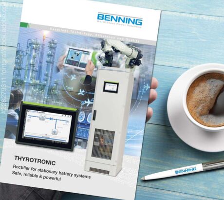 Table with coffee, biros and a BENNING THYROTRONIC brochure in hand